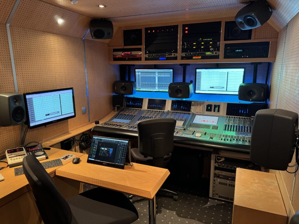 Tonstudio Übertragungswagen von Innen im Hintergrund ein Mischpult an der Wand und Decke Lautsprecher von Genelec für 7.1.4 Dolby Atmos